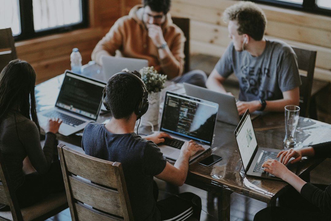 A team works together around a laptop.