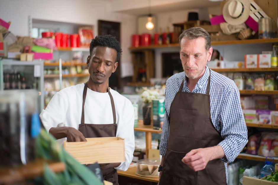 Employees organize products in a small grocery shop.