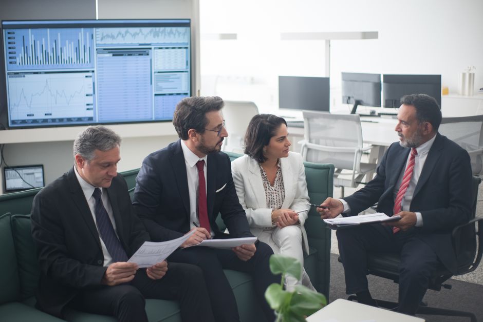 Business professionals discuss financial strategy in a modern office.