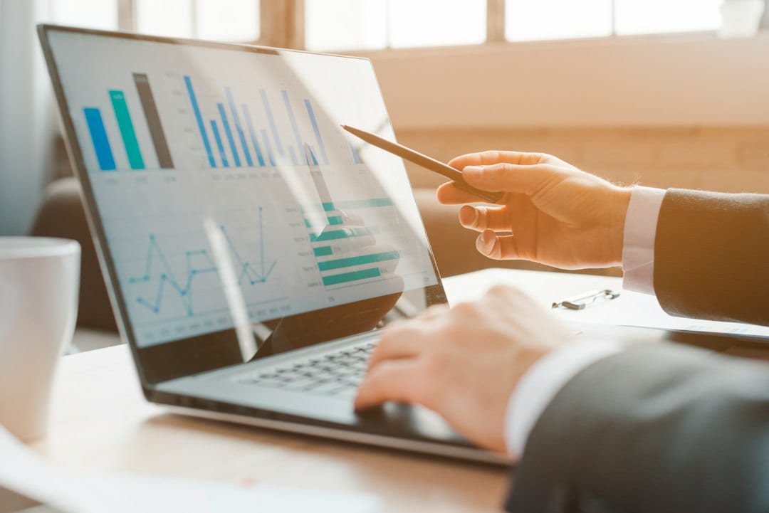 A person reviews business charts on a laptop.