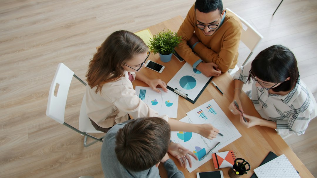 A diverse team reviews charts around a table.