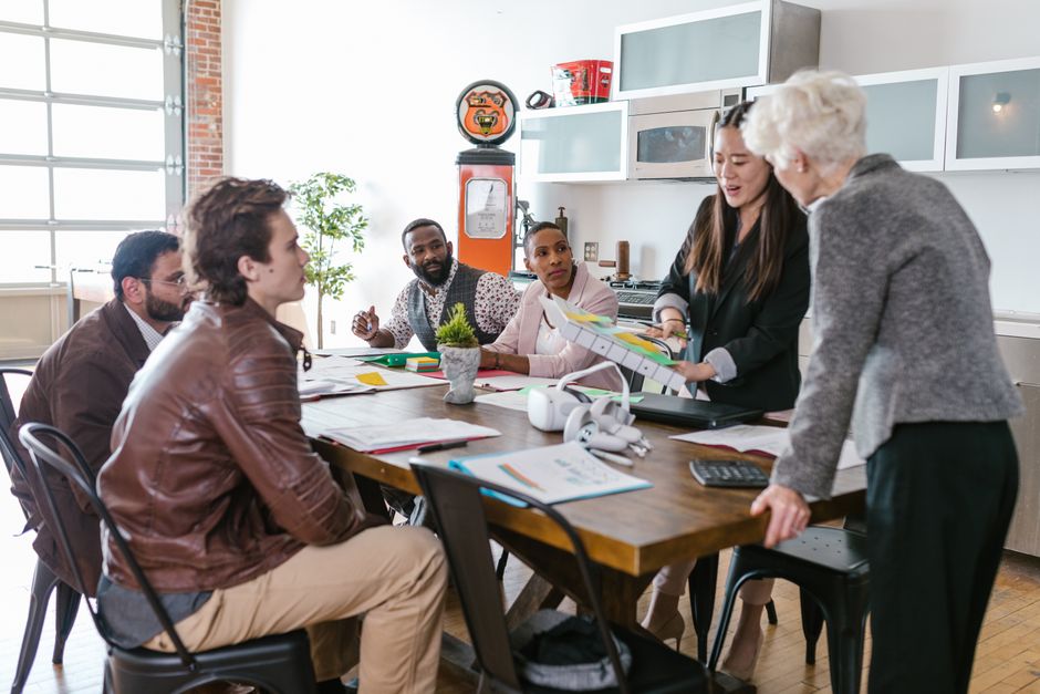 Colleagues work together around a meeting table.